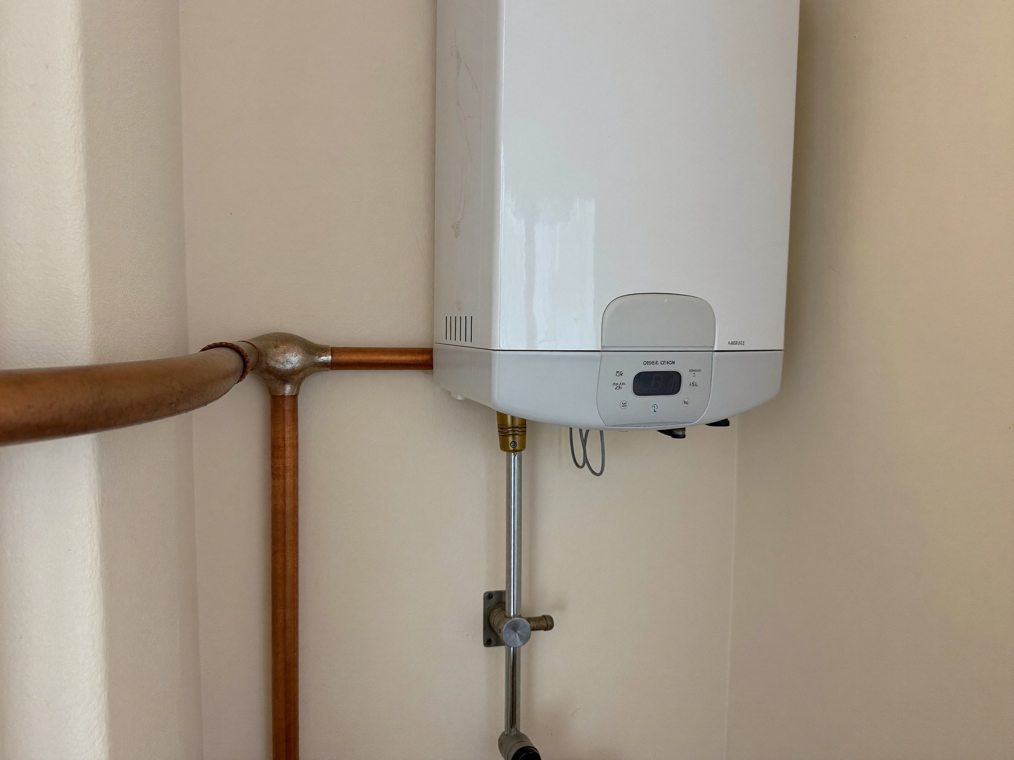 A newly installed tankless water heater on a utility-room wall